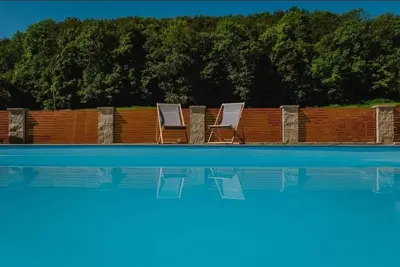two lounge chairs sitting next to a swimming pool at Soba pri nam in Gačnik