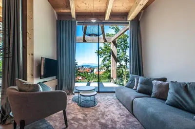 a living room with a couch and a large window at Studio na Stolbi in Ljubljana