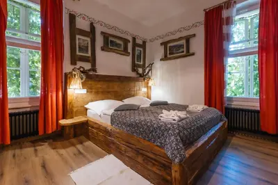 a bedroom with a wooden bed with red curtains at Rooms Murka in Bled