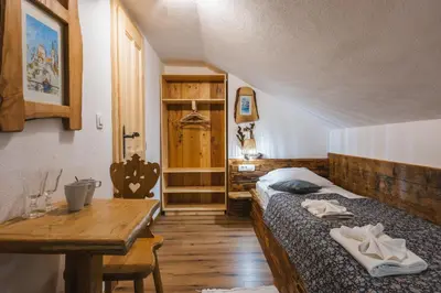 a bedroom with a bed and a wooden table at Rooms Murka in Bled