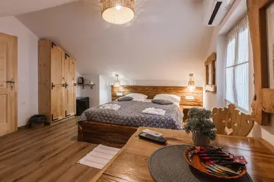 a bedroom with a large bed and a table at Rooms Murka in Bled