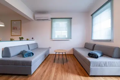 a living room with two couches and a table at MIZU APARTMA VAS LIPA OLIMJE in Podčetrtek