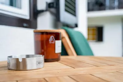 a metal bowl on a table with a bottle of sauce at MIZU APARTMA VAS LIPA OLIMJE in Podčetrtek