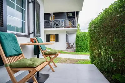 a pair of chairs sitting on a porch at MIZU APARTMA VAS LIPA OLIMJE in Podčetrtek