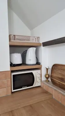 a microwave sitting on a shelf in a kitchen at Apartma Katarina in Bled