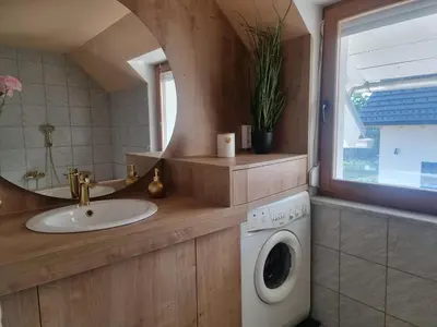 a bathroom with a sink and a washing machine at Apartma Katarina in Bled