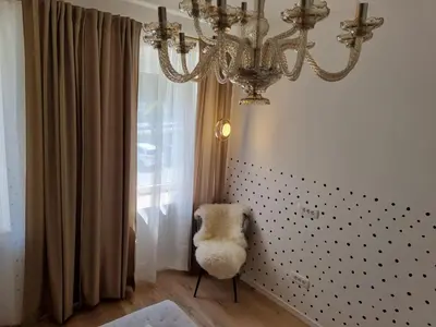 a chandelier and a chair in a room at Apartma Larisa in Bled