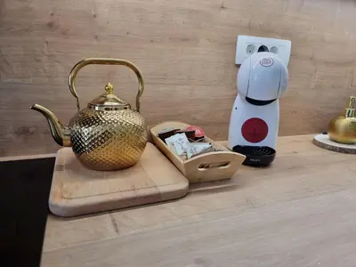a tea kettle on a cutting board next to a blender at Apartma Larisa in Bled