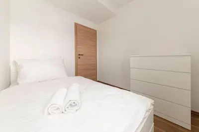 a bedroom with a white bed with towels on it at Frida's Place Ljubljana in Ljubljana