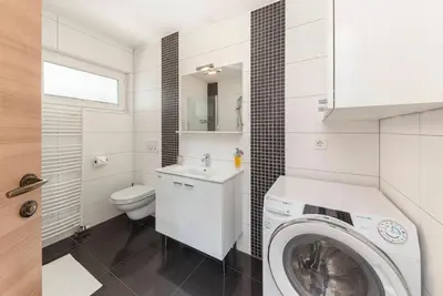a bathroom with a washing machine and a washer at Frida's Place Ljubljana in Ljubljana