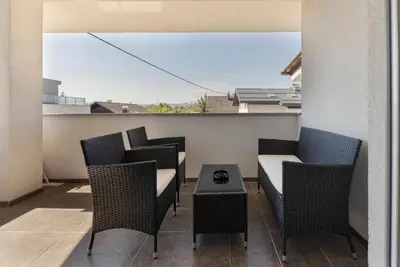 a patio with chairs and a table on a balcony at Frida's Place Ljubljana in Ljubljana