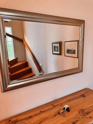 a mirror on a wall with a staircase in a room at Vila Minka Bled - Perfect Family Vacation Home in Bled