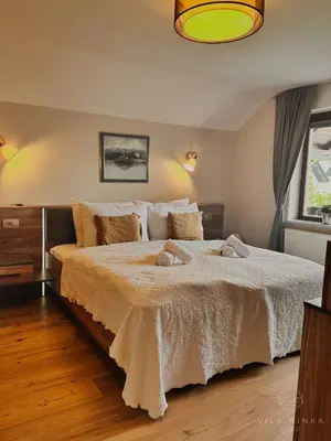a bedroom with a large bed with two towels on it at Vila Minka Bled - Perfect Family Vacation Home in Bled