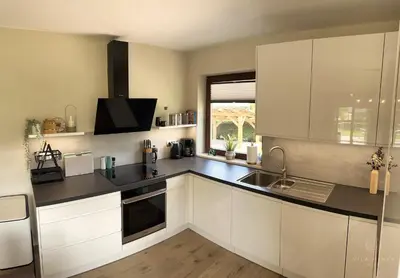 a kitchen with white cabinets and a sink at Vila Minka Bled - Perfect Family Vacation Home in Bled