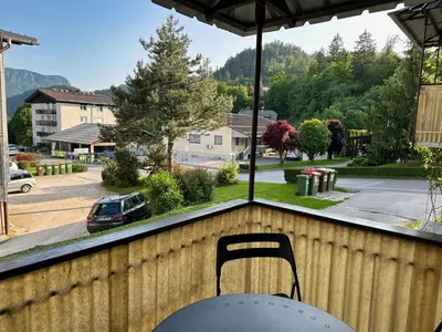 a table and chair on a porch with a view of a street at Nina's Place in Bled