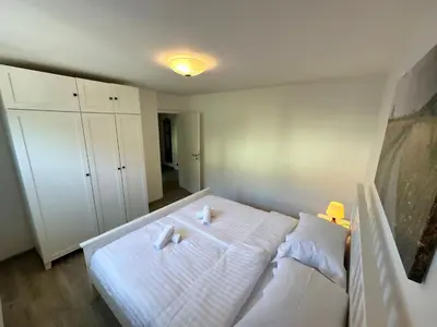 a bedroom with a white bed with two white pillows at Nina's Place in Bled