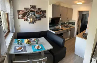 a living room and kitchen with a small table in a kitchen at Nina's Place in Bled
