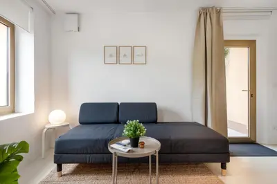 a living room with a blue couch and a table at Modern holiday home with terrace close to Nova Gorica in Miren