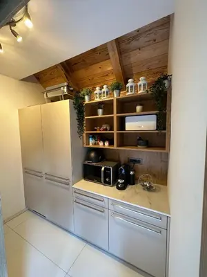a kitchen with a stainless steel refrigerator and wooden ceilings at The Vila Bled Premium Luxury Retreat in Bled