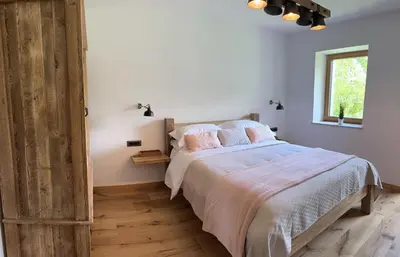 a bedroom with a bed with pink pillows and a window at The Vila Bled Premium Luxury Retreat in Bled