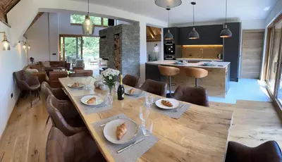 a dining room with a long wooden table and chairs at The Vila Bled Premium Luxury Retreat in Bled
