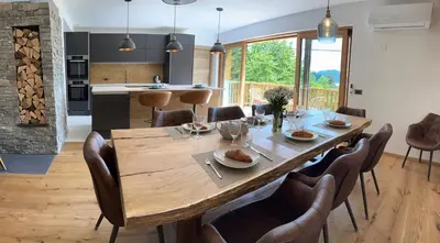 a kitchen and dining room with a large wooden table and chairs at The Vila Bled Premium Luxury Retreat in Bled