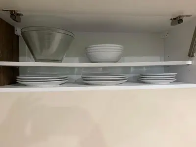 a white shelf with bowls and plates on it at Posestvo Tmžek in Bovec