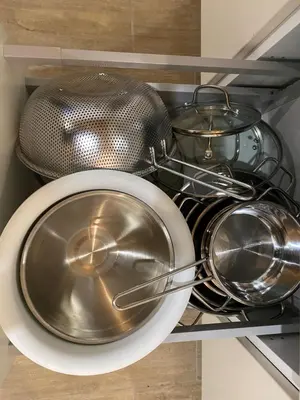 a pile of pots and pans in a drawer at Posestvo Tmžek in Bovec