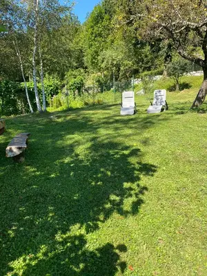 two white chairs sitting in a field of grass at Posestvo Tmžek in Bovec