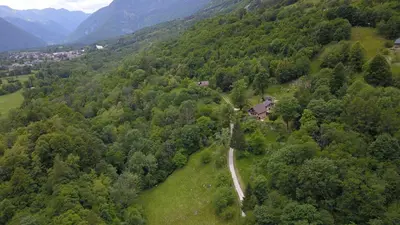 an aerial view of a winding road in a forest at Posestvo Tmžek in Bovec