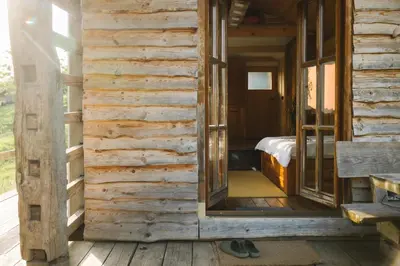 an open door to a bedroom in a log house at Ladybug Eco House in Gradišče pri Lukovici