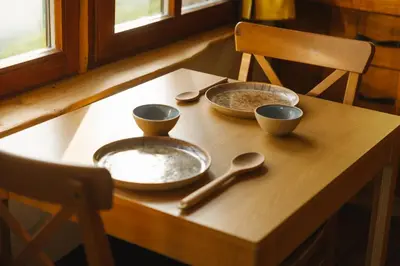a wooden table with three bowls and spoons on it at Ladybug Eco House in Gradišče pri Lukovici