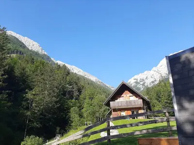 a house in the mountains with a fence at Camping & Glamping Grintovec in Preddvor