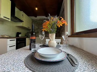 a table with a bowl and a vase of flowers on it at Pri Piskovih in Grgar