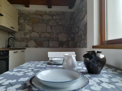 a kitchen table with a bowl and vases on it at Pri Piskovih in Grgar