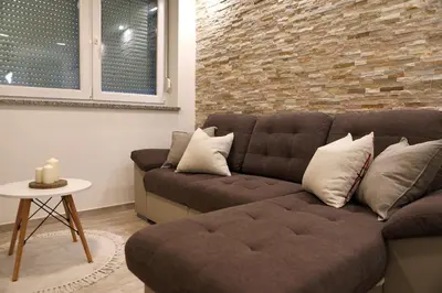 a living room with a couch and a brick wall at Esti’s Oasis in Ljubljana