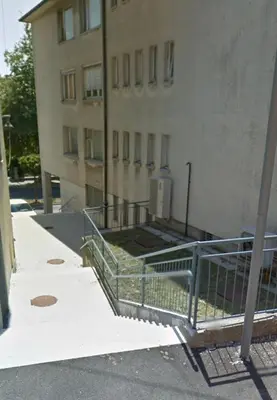 a building with a fence in front of a building at Lorume in Postojna