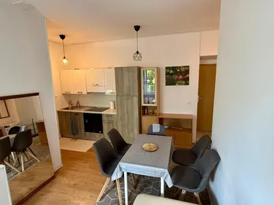 a kitchen and living room with a table and chairs at Lorume in Postojna