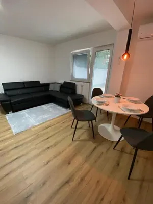 a living room with a black couch and a table at Ada Apartment in Ljubljana