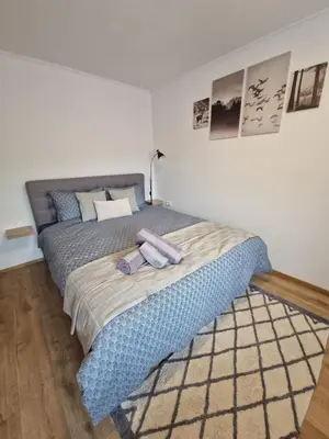 a bedroom with a large bed with a blue blanket at Greg's Rooms in Ilirska Bistrica