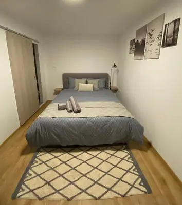 a bedroom with a large bed with a rug at Greg's Rooms in Ilirska Bistrica