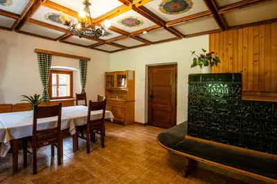 a dining room with a table and chairs and a ceiling at Traditional homestead Guhar in Radovna in Mojstrana