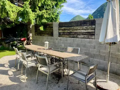 a table with chairs and an umbrella next to a wall at Apartma Zeus in Jesenice
