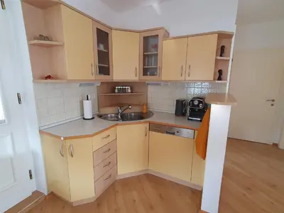 a small kitchen with yellow cabinets and a sink at Apartment Sonata in Kamnik