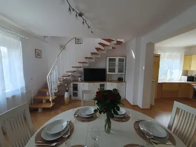 a dining room with a table and a staircase at Apartment Sonata in Kamnik