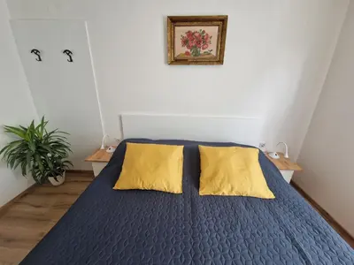 a bedroom with a blue bed with yellow pillows at Medeni Apartma in Pivka