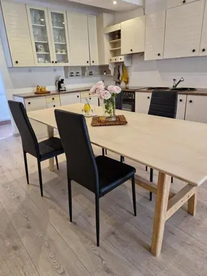 a kitchen with a wooden table and black chairs at Medeni Apartma in Pivka