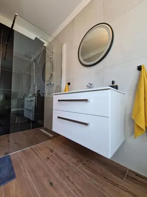 a bathroom with a white sink and a mirror at Medeni Apartma in Pivka