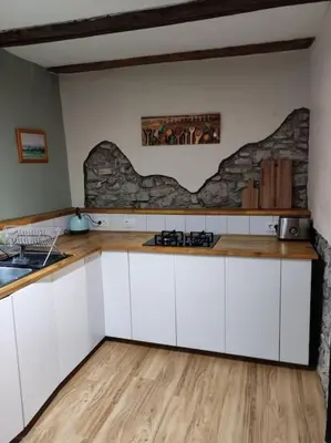 a kitchen with white cabinets and a stone wall at Casa di Volce - 1801 Stone House in Tolmin