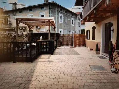 a patio with a fence and a wooden structure at Casa di Volce - 1801 Stone House in Tolmin